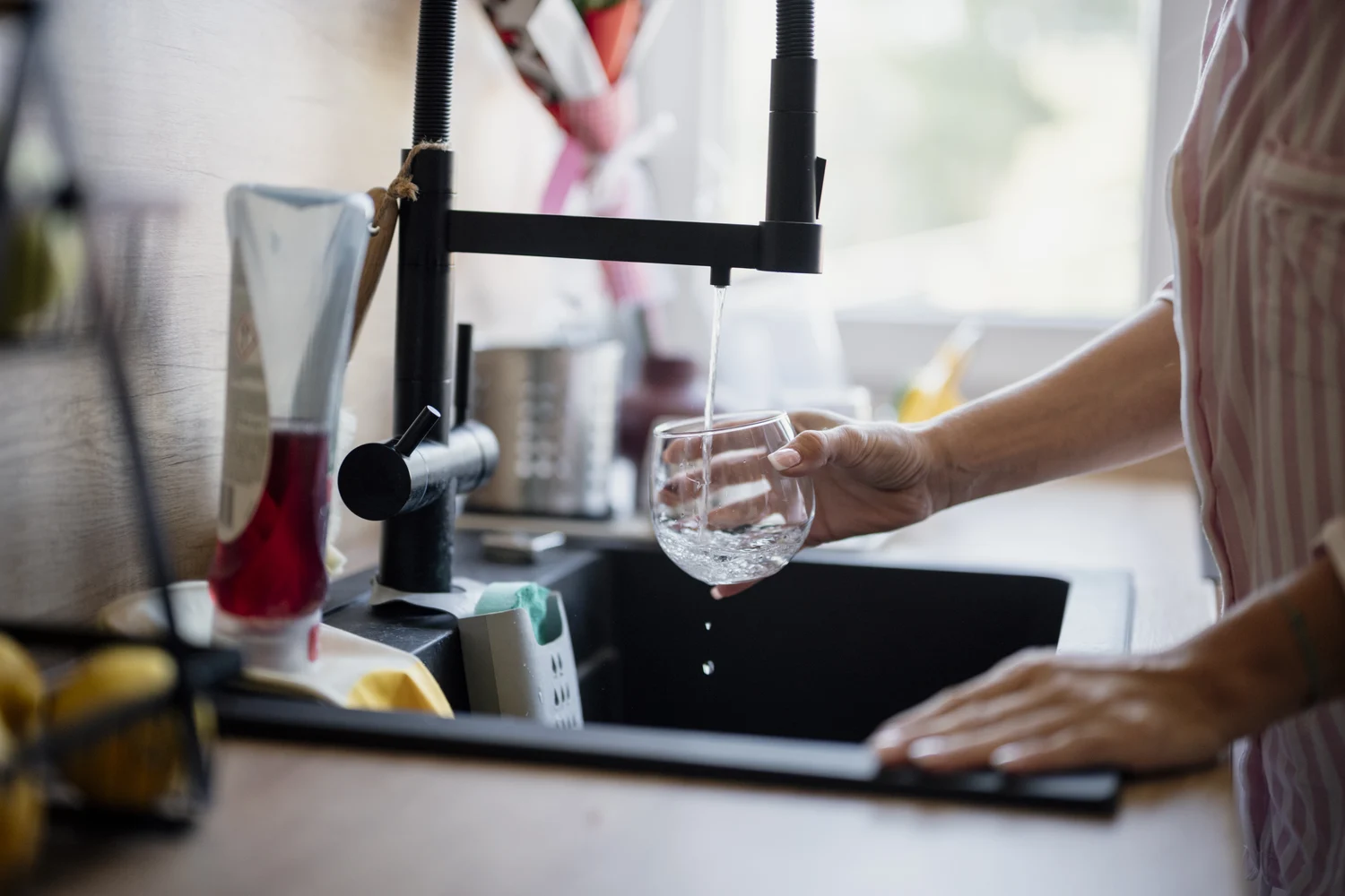 Water dat uit een keukenkraan in een glas stroomt